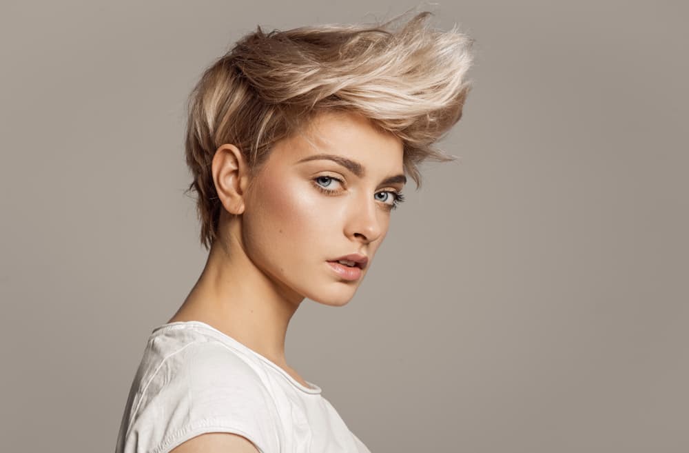 Woman with textured short blonde hair styled after cut and blow dry