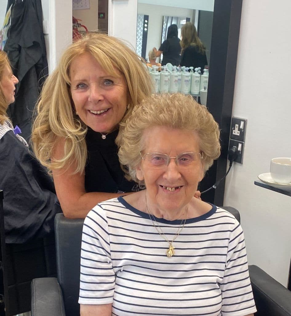 Debbie Wiseman, Style Director and salon owner at The Classic Hair Company in Tilbury, Essex, smiling with a client in the salon.