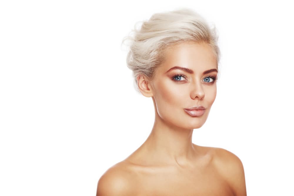 Woman with bright platinum blonde hair after full head bleach