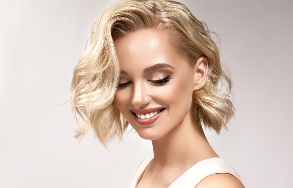 Woman with blonde wavy bob styled with full head highlights
