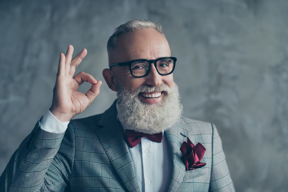 Smiling older man with grey hair and beard after gents haircut