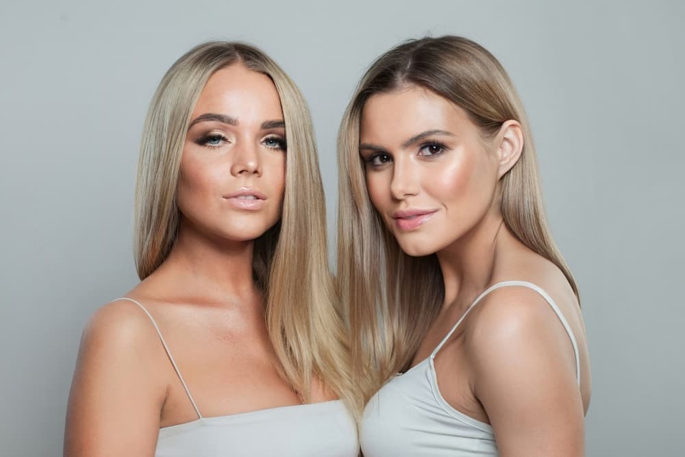 Two women with smooth, glossy blonde hair showing natural-looking highlights, styled at The Classic Hair Company in Tilbury.