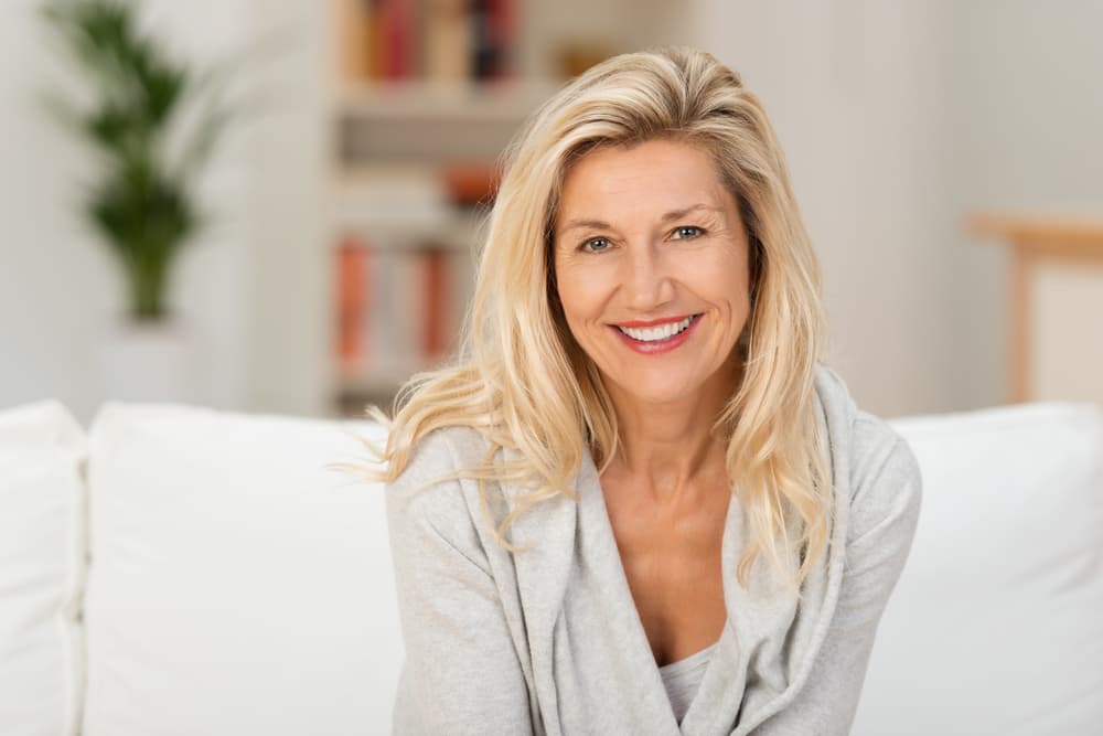 Smiling woman with long blonde hair styled with half head highlights