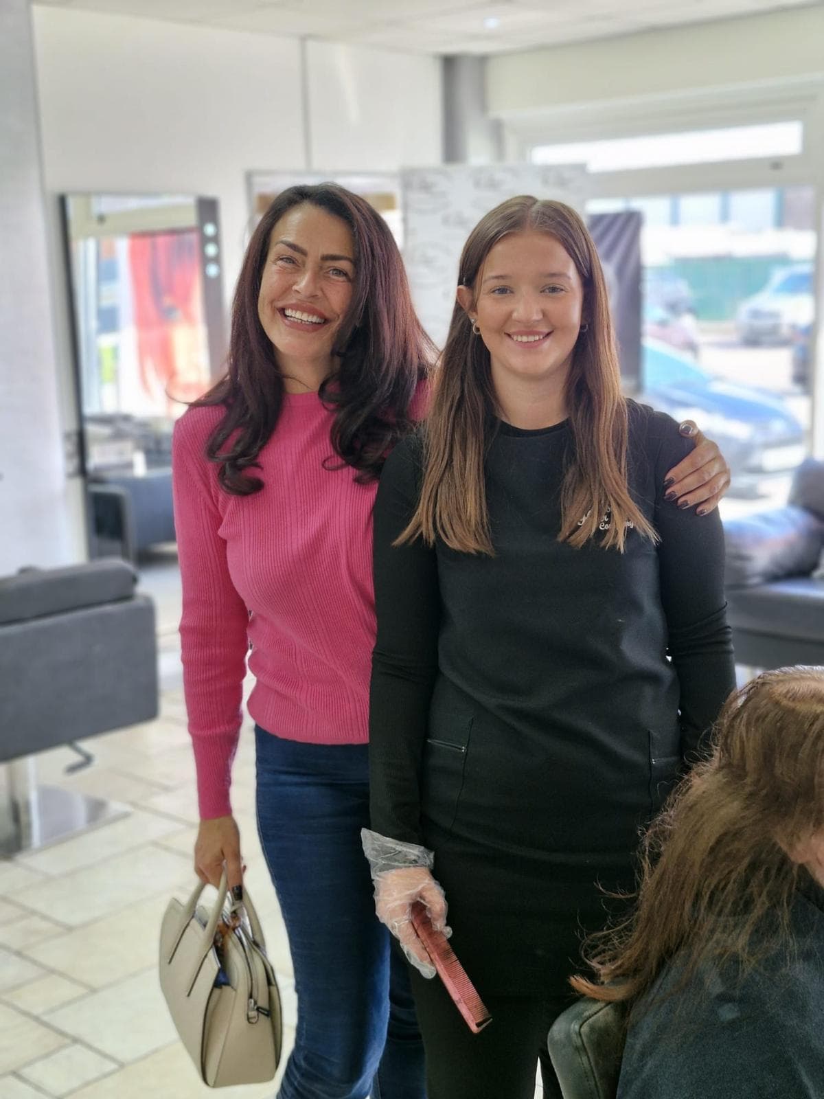 Holly Frew, Stylist at The Classic Hair Company in Tilbury, Essex, smiling in the salon with a client during a hair appointment.