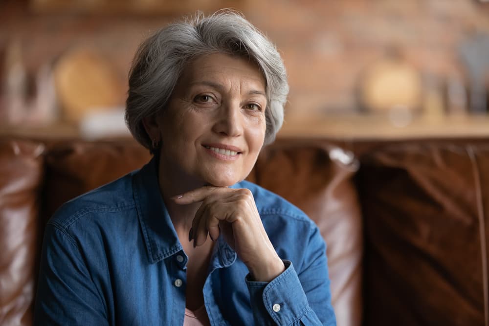 Mature woman with short grey hair smiling after ladies cut and finish