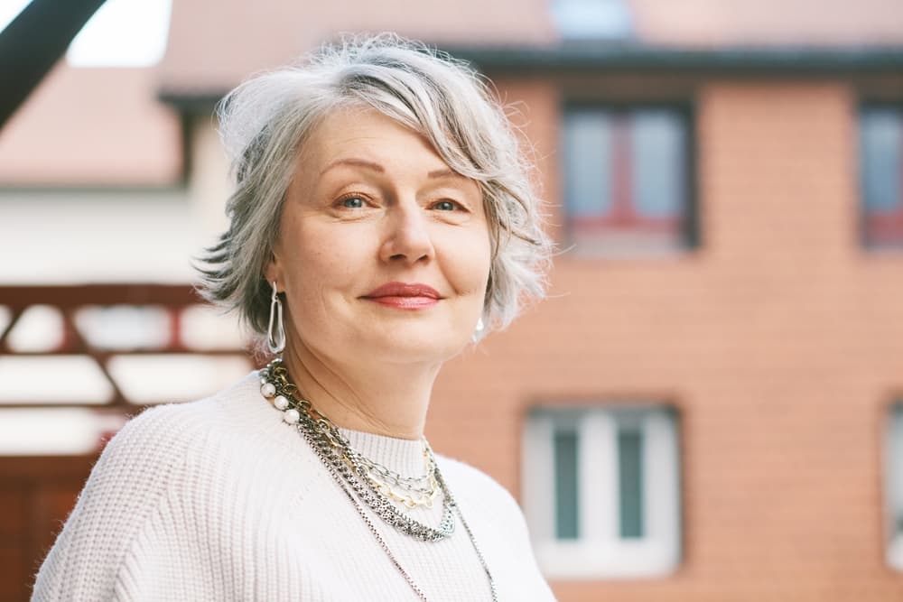 Mature woman with short layered grey haircut smiling