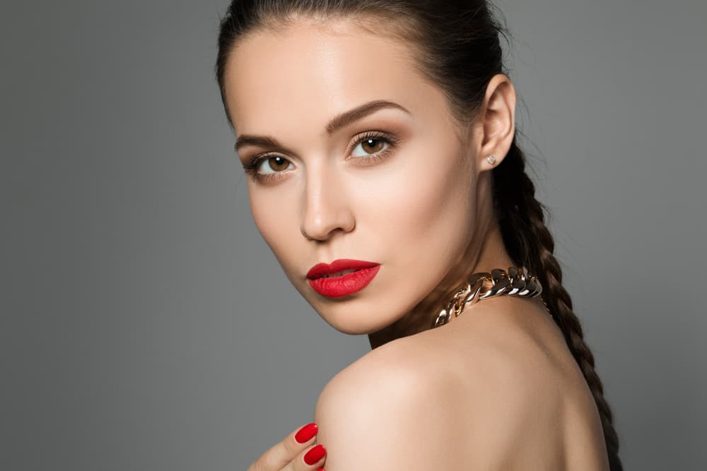 Woman with sleek braided hairstyle looking over shoulder