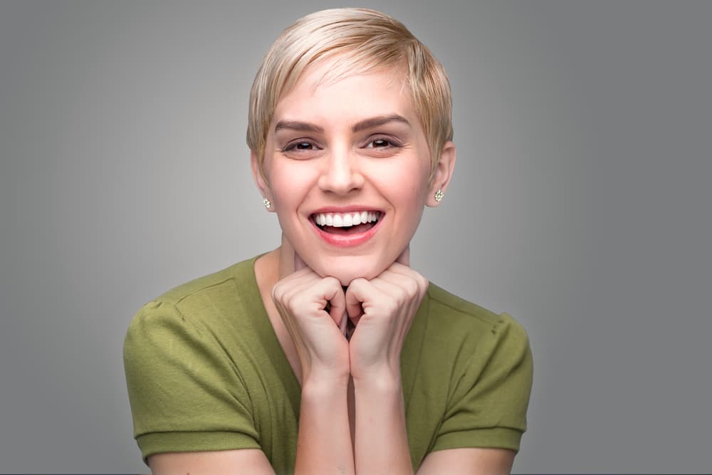 Smiling woman with short blonde pixie cut styled after restyle and blow dry