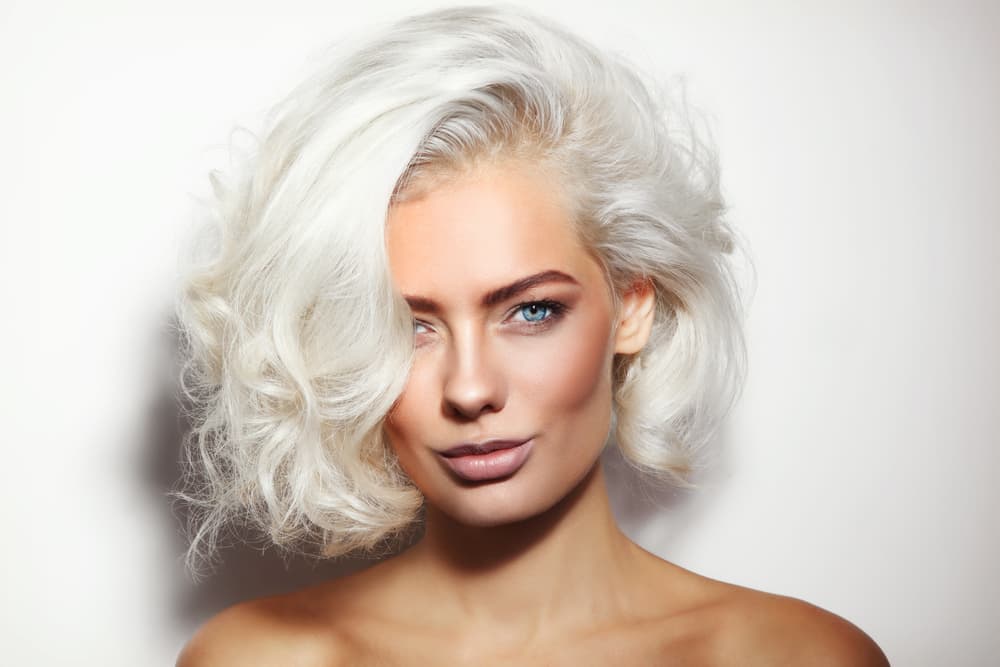 Woman with bright platinum blonde hair after professional root bleach