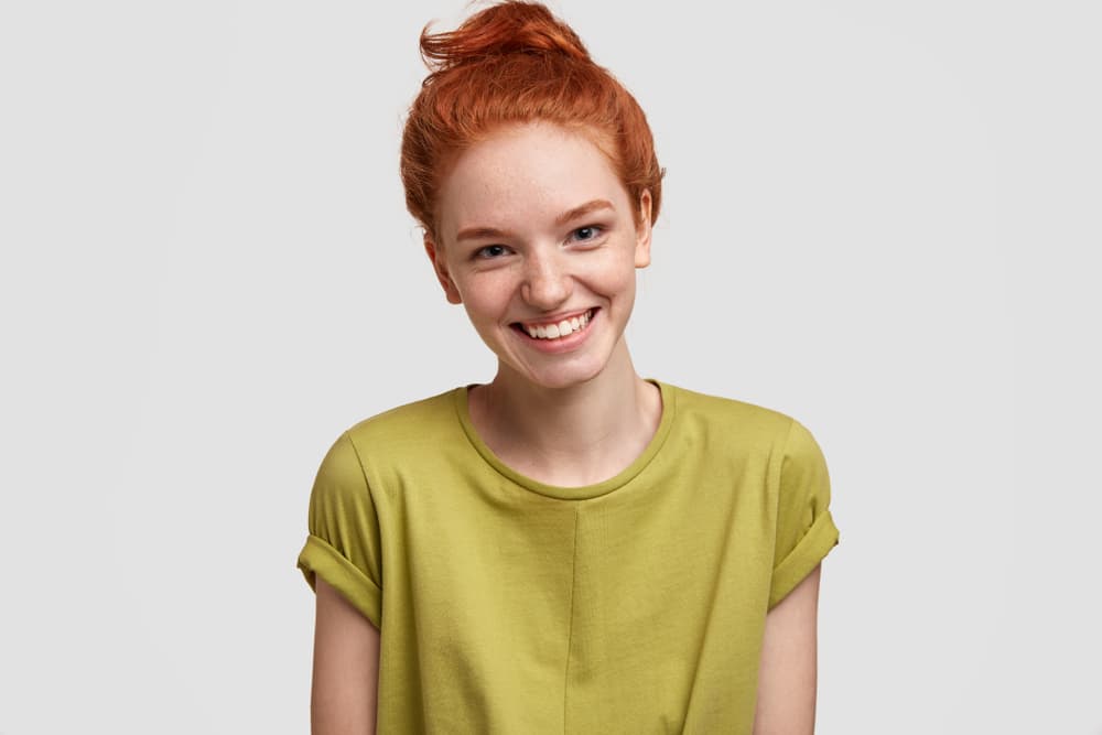 Young woman smiling with fresh clean hair after shampoo and dry off
